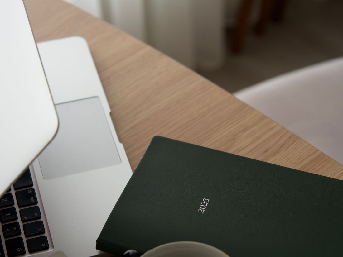 Schreibtisch mit Laptop und Notizbuch in warmem Tageslicht — Arbeitsweise von Lumina
